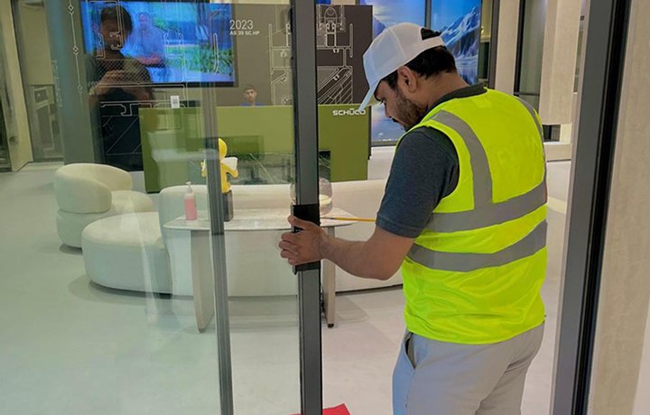 Technician repairing a glass door lock to ensure secure locking